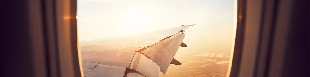 View of wing from airplane window at sunset